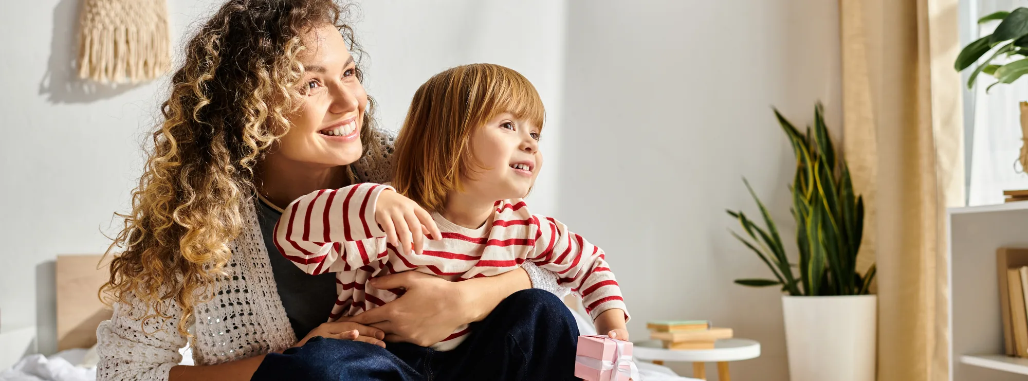 A mother and young daughter smiling together at home